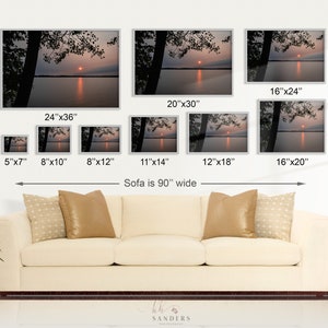 May include: A collage of eight different sizes of a photograph of a sunset over a lake. The photo shows a silhouette of trees in the foreground and a bright orange sun setting over the water. The caption below the images reads "Sofa is 90" wide".