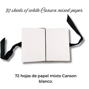Puede incluir: Un bloc de papel mixto Canson blanco abierto con 72 hojas, atado con una cinta negra. El texto "72 hojas de papel mixto Canson blanco" est&aacute; en la imagen.