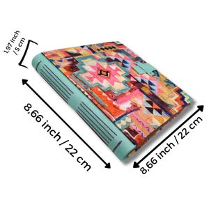 May include: A colorful journal with a geometric pattern in pink, orange, and blue. The journal is 8.66 inches (22 cm) long and 1.97 inches (5 cm) thick. The cover has a turquoise spine and a matching clasp.