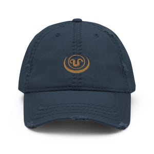 May include: A navy blue distressed baseball cap with a gold embroidered logo of a stylized letter U inside a circle.