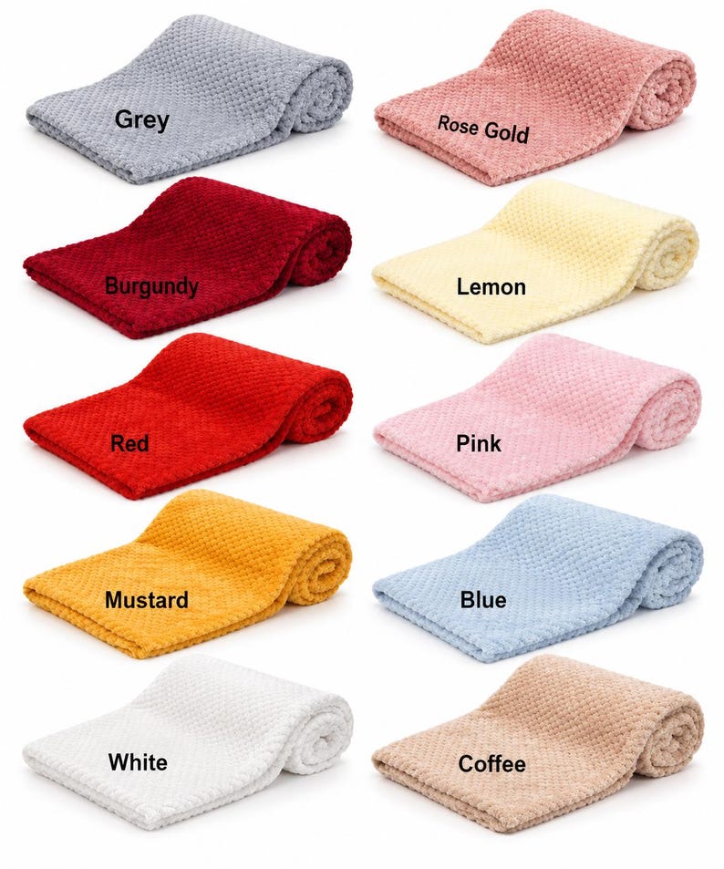May include: A collection of ten folded blankets with a textured waffle-knit pattern, each labeled with its color: Grey, Rose Gold, Burgundy, Lemon, Red, Pink, Mustard, Blue, White, and Coffee. The blankets are arranged in two columns.