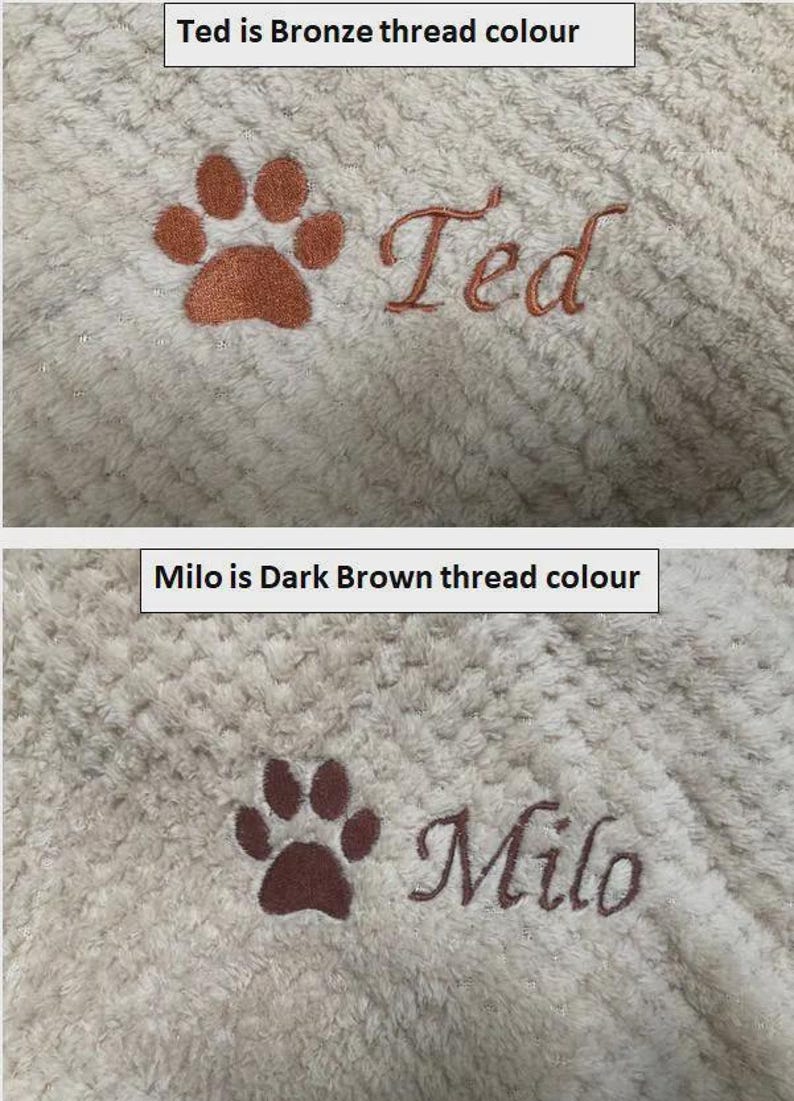 May include: A cream-colored textured fabric featuring two embroidered designs. The top design shows a bronze paw print and the name Ted. The bottom design shows a dark brown paw print and the name Milo. Text labels indicate Ted is bronze thread colour and Milo is dark brown thread colour.