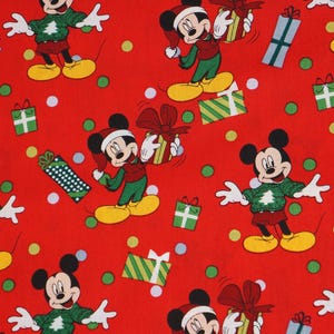 May include: A red fabric featuring a repeating pattern of Mickey Mouse characters. Some figures wear green sweaters with white tree designs, while others wear Santa hats and hold wrapped gifts. Green and white polka dots fill the background.