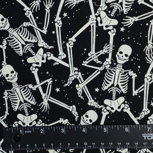 Tela de Halloween con esqueletos que brillan en la oscuridad, tela de algodón para patchwork Benartex con estampado de esqueletos sobre fondo negro que brilla en la oscuridad, modelo 12542G-12B imagen 3