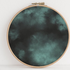 May include: A dark green and black watercolor-style design on a round canvas stretched over a wooden embroidery hoop.