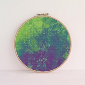 Peut inclure: Un tambour à broder circulaire en bois contenant un tissu avec un motif abstrait imprimé. Le tissu présente un dégradé passant d'un vert citron vif en haut à un violet profond en bas, agrémenté de détails texturés sur toute la surface.