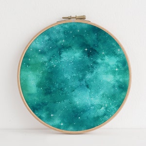 May include: A teal blue watercolour painting of a starry night sky in a wooden embroidery hoop.