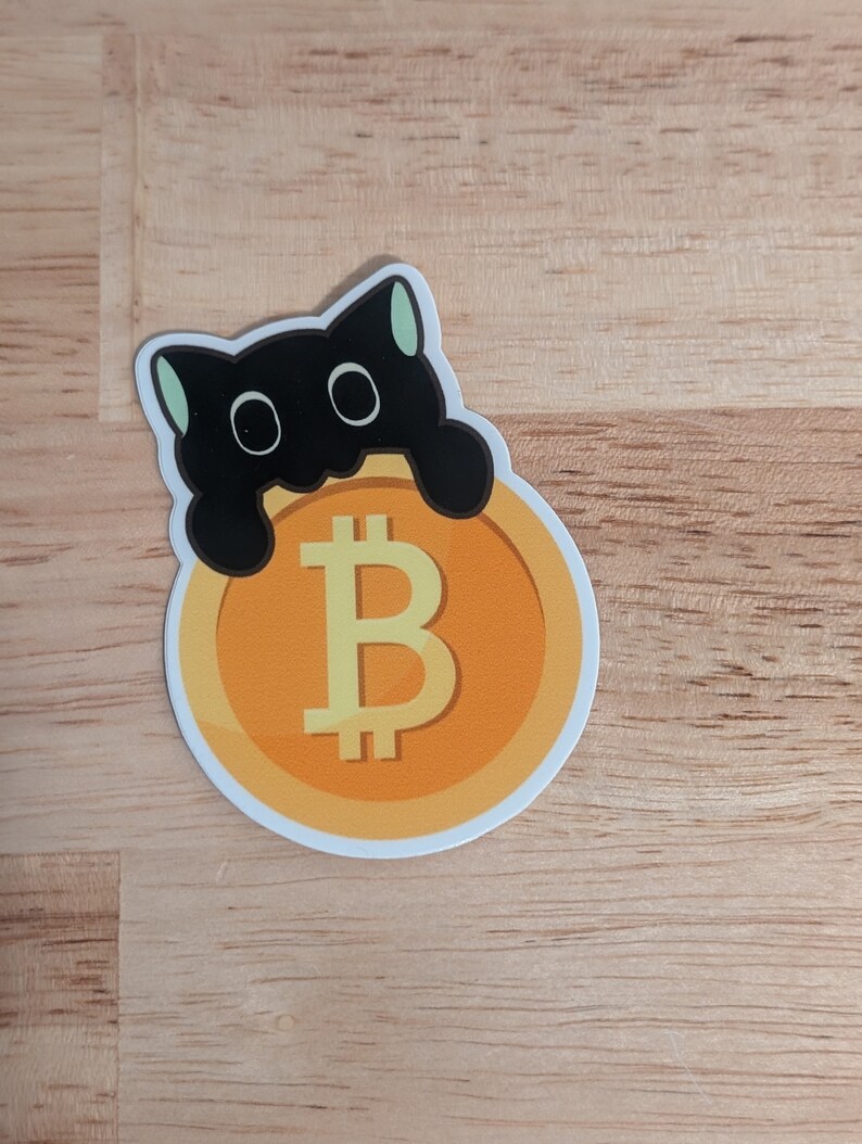 May include: A black cat sticker with big eyes holding a yellow and orange Bitcoin coin sticker.