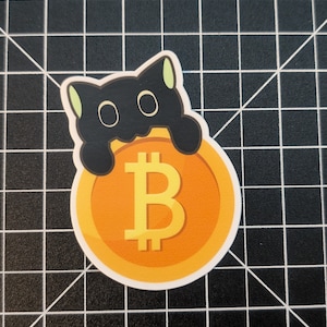 May include: A black cat sticker with green ears holding a gold coin with a Bitcoin symbol.