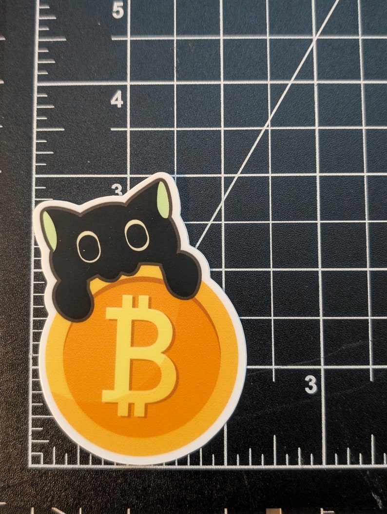 May include: A black cat with green ears peeking out from behind a large gold coin with a yellow Bitcoin symbol.