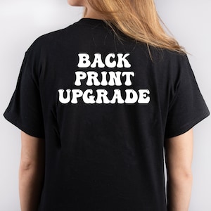 May include: Black t-shirt with white text that reads "BACK PRINT UPGRADE" in a retro font.