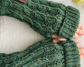 May include: A pair of green fingerless gloves with a brown leather tag that says "Handmade by Abby Knits". The gloves are made of a thick, textured yarn and have a cable knit pattern.