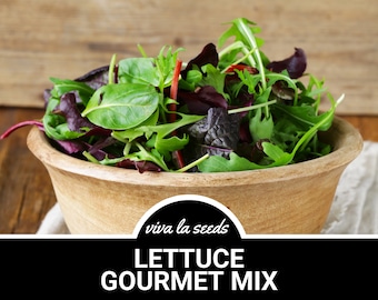 May include: A wooden bowl filled with a mix of fresh green and red lettuce leaves. The bowl is on a white linen cloth and a wooden surface. The text "viva la seeds LETTUCE GOURMET MIX" is on a black background.