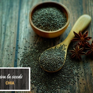 May include: A wooden bowl and spoon filled with chia seeds, with star anise scattered around them on a wooden surface. The text "viva la seeds CHIA" is on a black and white wooden sign.