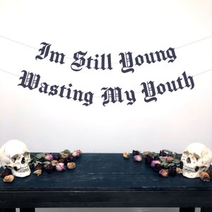 Banner con la letra gótica "Todavía soy joven y estoy desperdiciando mi juventud", banner de cumpleaños número 30, banner de cumpleaños alternativo, banner de cumpleaños emo, decoración de cumpleaños