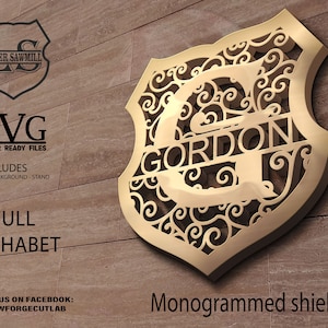 Può includere: Uno scudo monogrammato color oro con il nome "GORDON" ritagliato. Lo scudo presenta un design ornato e a spirale. L'immagine include il testo "SVG Laser Ready Files" e "Full Alphabet".