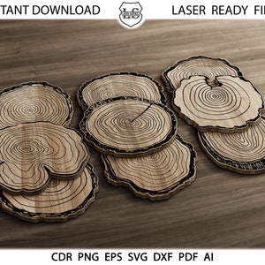 May include: Set of six wooden coasters with a tree ring design. The coasters are stacked on top of each other and have a natural wood finish.