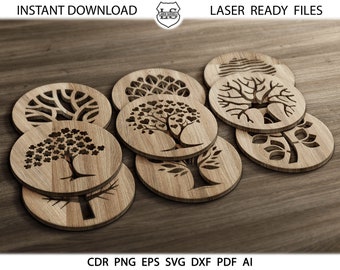 May include: Set of eight wooden coasters featuring laser-cut tree designs. Each coaster has a different tree design, including a tree with hearts, a tree with leaves, and a tree with branches. The coasters are arranged in a circle on a wooden surface.