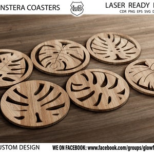 May include: Six wooden coasters featuring a laser-cut monstera leaf design. The coasters are arranged on a wooden surface.