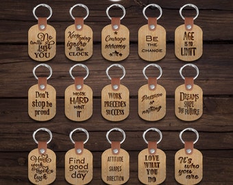 May include: A set of 12 laser-cut wooden keychains with inspirational quotes. The keychains are oval-shaped and feature a variety of sayings, including "Work Hard Want It", "Age is No Limit", and "Love What You Do".