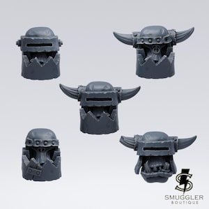 Puede incluir: Cinco componentes de casco en miniatura de resina gris con bordes inferiores dentados y ranuras oculares horizontales. Tres cascos incluyen cuernos curvos que se extienden desde los lados, mientras que dos no tienen cuernos. El texto SMUGGLER BOUTIQUE aparece en la esquina inferior derecha.