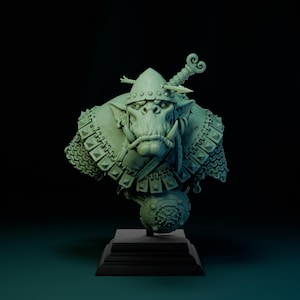 Op de afbeelding: Een groen geverfd buste van een Orc-krijger die een helm en een kettingharnas draagt. De Orc heeft een woeste uitdrukking en houdt een zwaard vast. De buste is gemonteerd op een zwarte basis.