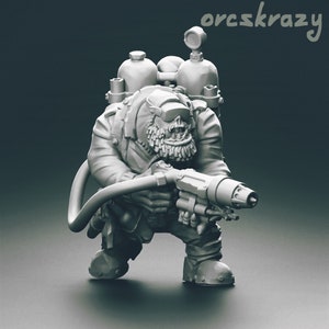 Op de afbeelding: Een grijs plastic miniatuurfiguur van een ork met een helm op en een groot geweer in de hand. De ork draagt een rugzak met twee tanks op zijn rug. Het figuur is in een gehurkte houding geposeerd, met het geweer gericht.