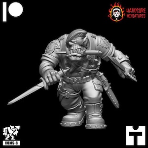 Op de afbeelding: Een grijze plastic miniatuurfiguur van een Orc die een militair uniform draagt en een mes vasthoudt. De Orc heeft een woeste uitdrukking en draagt een pet met een ster erop. De miniatuur maakt deel uit van een set miniaturen voor tabletop-spellen.
