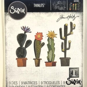 Op de afbeelding: Sizzix Thinlits stansvormenset met vier cactusontwerpen in potten en met bloemen. De set bevat negen stansvormen voor papierknutselprojecten. De tekst "Sizzix" en "Jim Holtz" is inbegrepen.