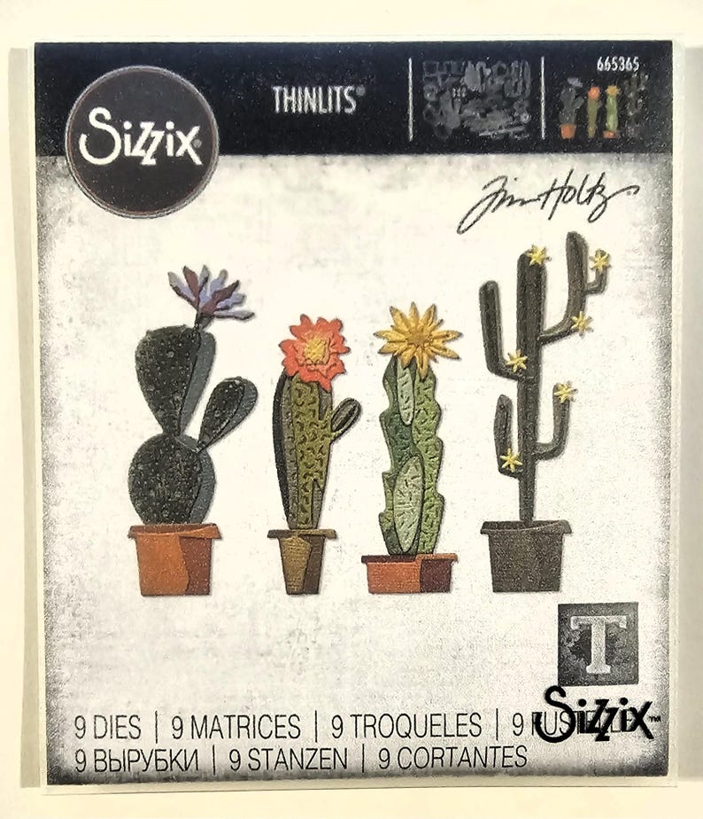 Op de afbeelding: Sizzix Thinlits stansvormenset met vier cactusontwerpen in potten en met bloemen. De set bevat negen stansvormen voor papierknutselprojecten. De tekst "Sizzix" en "Jim Holtz" is inbegrepen.