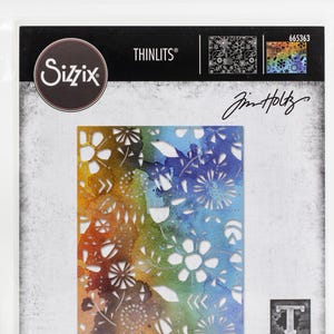 May include: A Sizzix Thinlits die set featuring a floral design with a watercolor effect in shades of orange, green, and blue. The package includes the text "THINLITS" and "Jim Holtz". The die-cut design includes flowers and leaves.