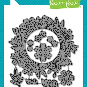 May include: A die-cut metal floral wreath with various flower and leaf shapes. The design includes the text "lawn cuts" and "lawn fawn". The product is labeled "Magic Iris Floral Wreath Add-On" and is made in the USA.