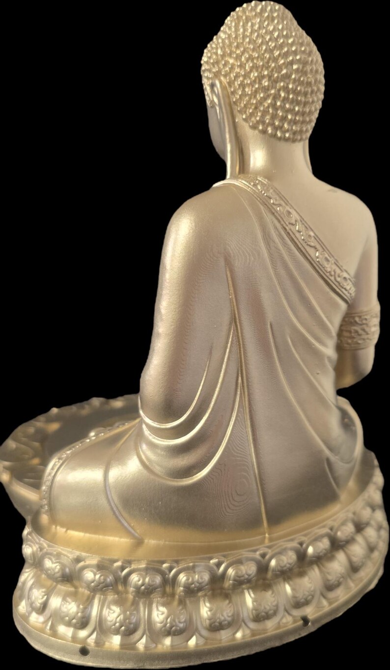 K&ouml;nnte beinhalten: Eine goldfarbene Buddha-Statue in sitzender Meditationshaltung. Die Statue weist auf der Robe und dem Lotus-Sockel aufwendige Details auf. Der Hinterkopf ist sichtbar, mit einem strukturierten Haardesign. Der Hintergrund ist schwarz.
