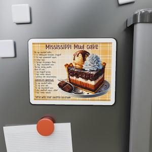 May include: A rectangular magnet featuring a recipe for Mississippi Mud Cake. The image shows a slice of the cake with ice cream and whipped cream. The recipe includes ingredients and instructions. The magnet is on a refrigerator.