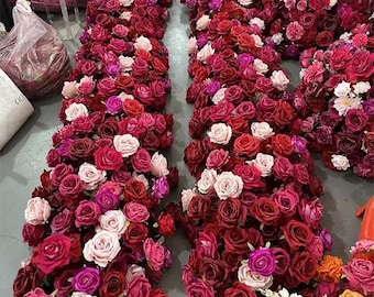 May include: A large arrangement of artificial red and pink roses, perfect for a wedding or special event. The roses are arranged in a cascading style, creating a romantic and elegant look.