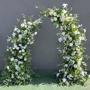May include: A white floral archway made of greenery and white flowers. The archway is perfect for a wedding ceremony or other special event.