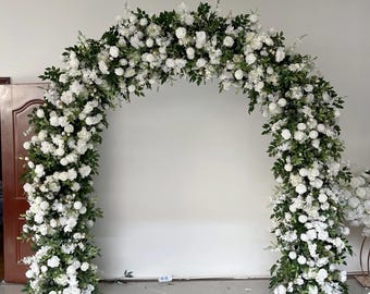 May include: A white and green floral archway made of artificial flowers and greenery. The archway is perfect for a wedding ceremony or other special event.