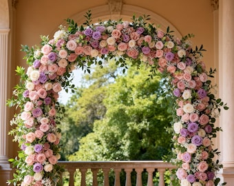 Könnte beinhalten: Ein dekorativer Blumenbogen, ideal für Hochzeiten, ist mit rosa, lavendelfarbenen und weißen Rosen geschmückt. Grüne Blätter und Laub sind in der Anordnung verstreut und schaffen eine romantische und elegante Präsentation. Der Bogen befindet sich vor einem Balkon und grünen Bäumen.