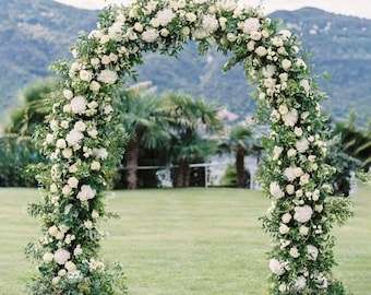May include: A white floral archway made of white roses and greenery, perfect for a wedding ceremony or other special event.