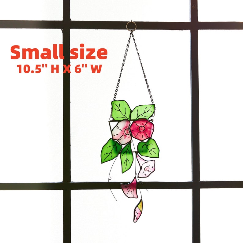Peut inclure: Une suspension en verre teint&eacute; repr&eacute;sentant des fleurs roses et blanches avec des feuilles vertes. La suspension mesure 26,7 cm de haut et 15,2 cm de large. Le texte "Small size 10.5" H x 6" W" est visible sur l'image.