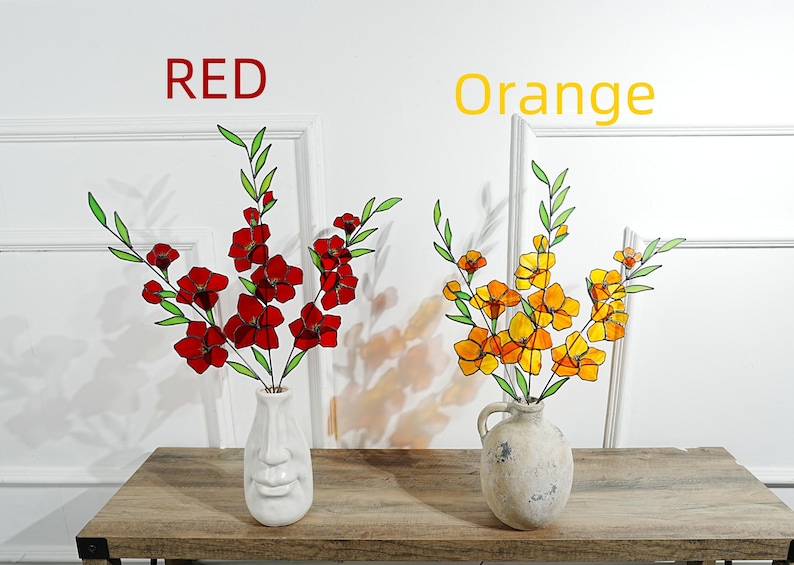May include: Two vases of artificial flowers on a wooden table. One vase holds red flowers, the other holds orange flowers. The text "RED" and "Orange" are above the vases. The vases have a face design.