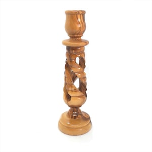 May include: A wooden candle holder with a twisted design. The holder is made of olive wood and has a natural finish. It is a beautiful and unique piece that would make a great gift.