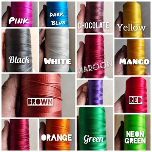 K&ouml;nnte beinhalten: Eine Sammlung von Garnrollen in verschiedenen Farben, darunter Pink, Dunkelblau, Schokolade, Gelb, Schwarz, Wei&szlig;, Rotbraun, Mango, Braun, Rot, Orange, Gr&uuml;n und Neongr&uuml;n.