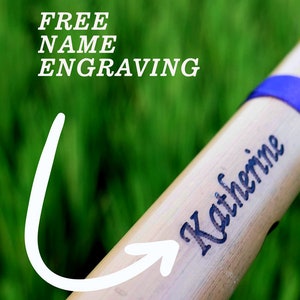 K&ouml;nnte beinhalten: Nahaufnahme einer Bambusfl&ouml;te mit dem eingravierten Namen "Katherine". Der Text "FREE NAME ENGRAVING" ist im Hintergrund sichtbar.