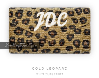 Könnte beinhalten: Goldene Clutch mit Leopardenmuster aus Perlen mit den Buchstaben "JDC" in dicker weißer Schrift.