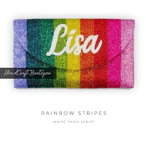 Może przedstawiać: Torebka typu clutch z koralików w paski tęczowe z imieniem "Lisa" w grubym białym napisie.