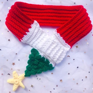 May include: A crocheted Christmas tree scarf in red, white, and green with a yellow star on top.