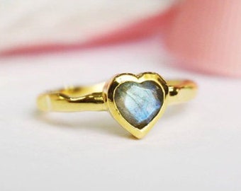 May include: A gold heart-shaped ring with a blue labradorite gemstone.
