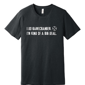 Könnte beinhalten: Ein dunkelgraues T-Shirt mit weißem Text, der "I do gamechanger. I'm kind of a big deal." lautet, und einer weißen Baseballgrafik.