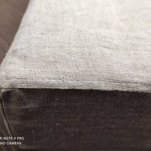 Puede incluir: Primer plano de un coj&iacute;n de lino beige con un tejido beige ligeramente m&aacute;s oscuro en el borde inferior.